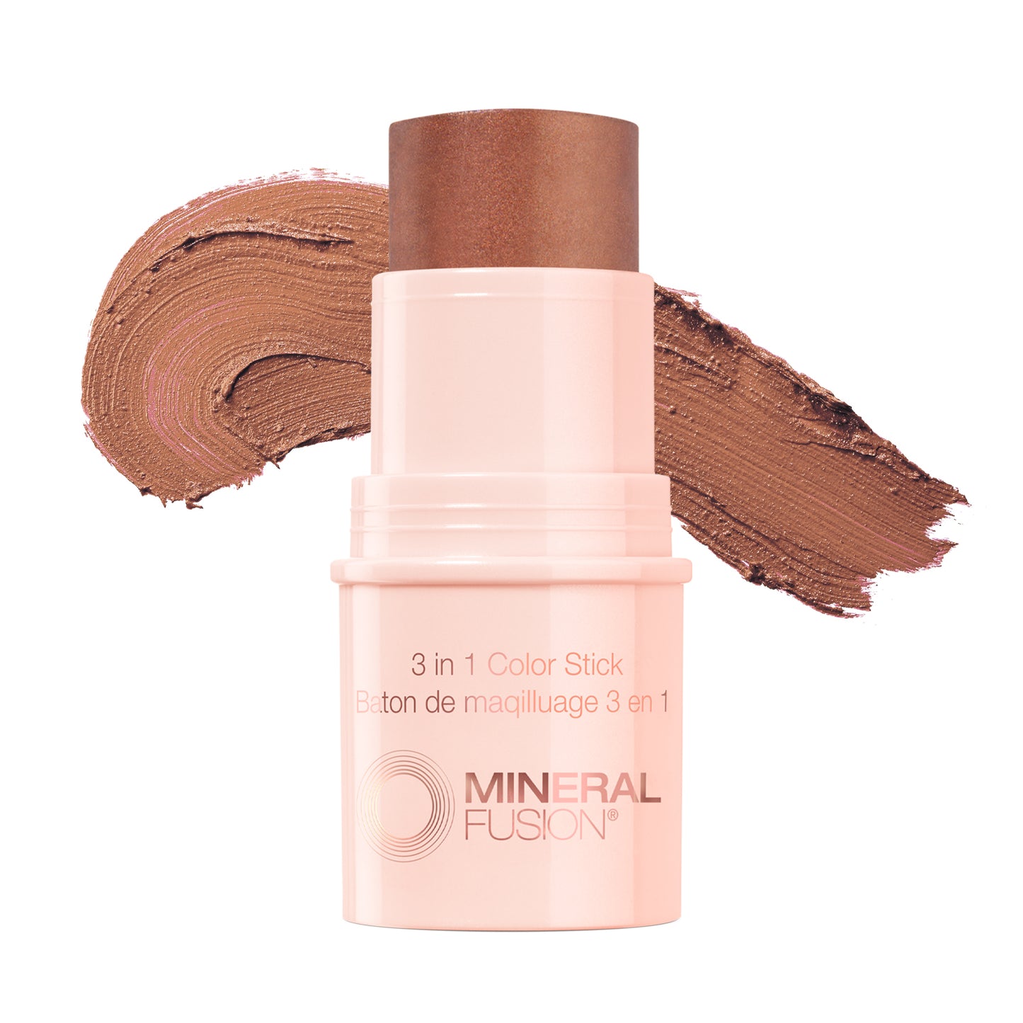 This image features the Mineral Fusion 3-in-1 Color Stick, presented in a soft pink shade. The product is shown both in its compact form and alongside its packaging, which highlights its multifunctional use as a color stick, blush, and highlighter.