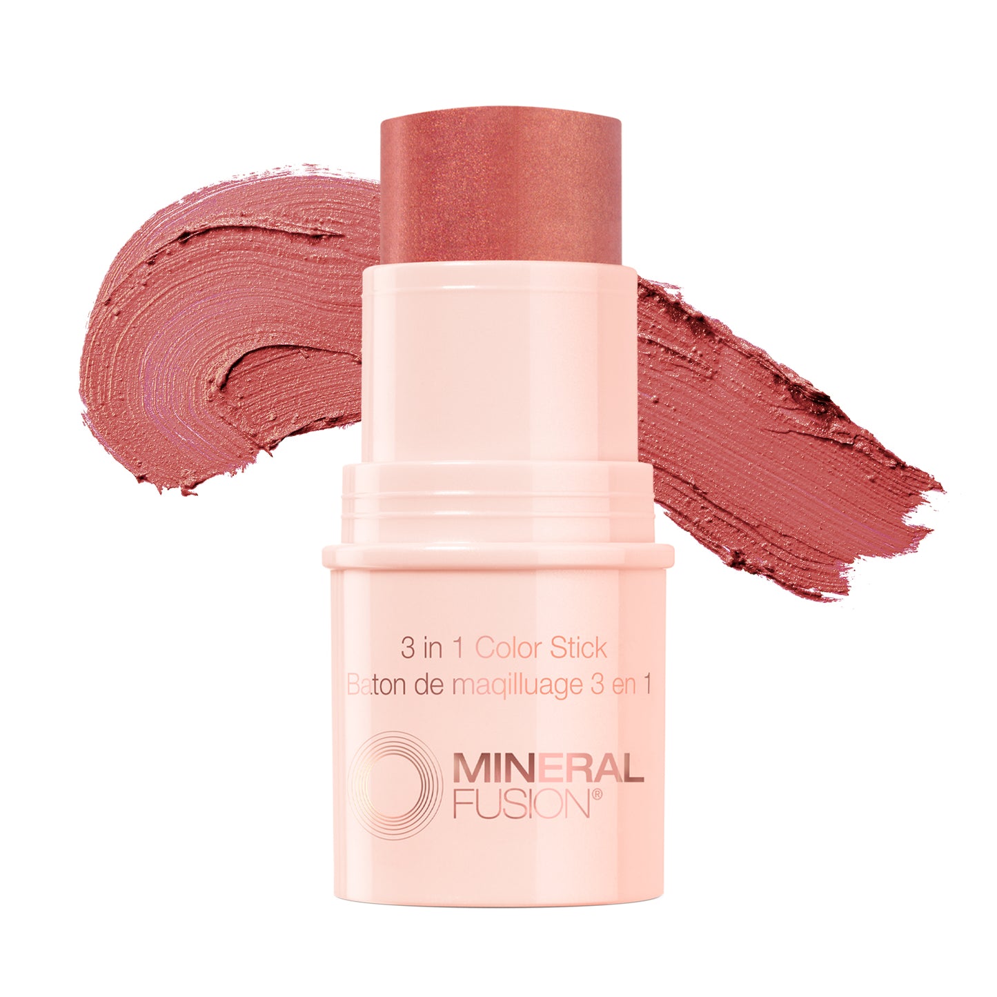 This image features the Mineral Fusion 3-in-1 Color Stick, presented in a soft pink shade. The product is shown both in its compact form and alongside its packaging, which highlights its multifunctional use as a color stick, blush, and highlighter.