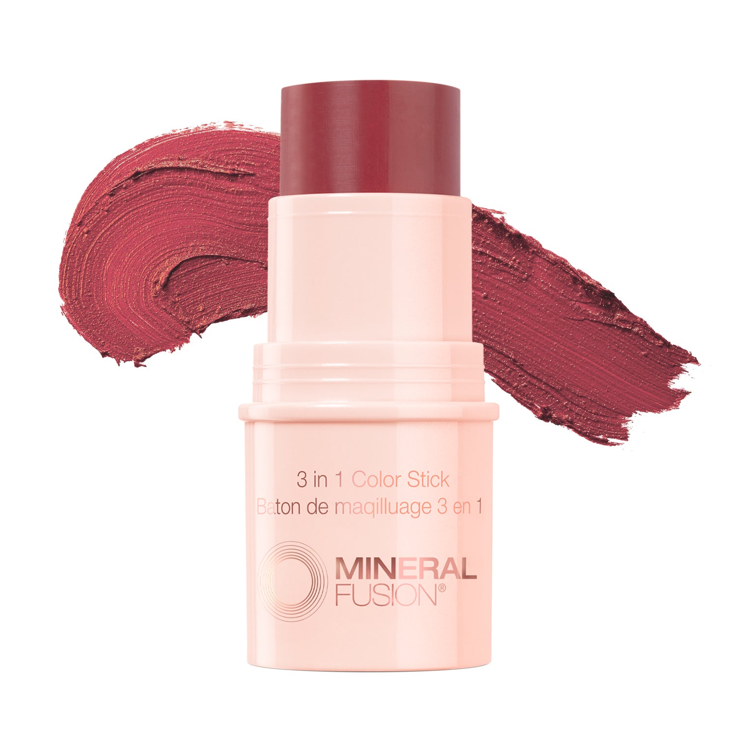 This image features the Mineral Fusion 3-in-1 Color Stick, presented in a soft pink shade. The product is shown both in its compact form and alongside its packaging, which highlights its multifunctional use as a color stick, blush, and highlighter.